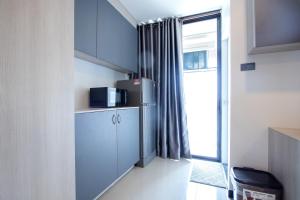 uma pequena cozinha com um frigorífico e uma janela em 44 Residence and Resort em Khlong Luang