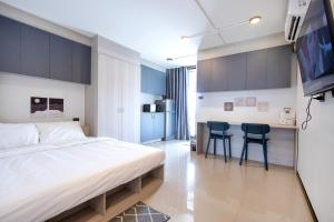 sypialnia z łóżkiem i 2 krzesłami oraz kuchnia w obiekcie 44 Residence and Resort w mieście Khlong Luang