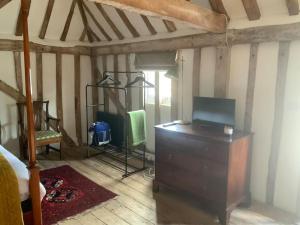 a bedroom with a dresser with a tv on it at The Granary at Duchess Farm in Sawbridgeworth