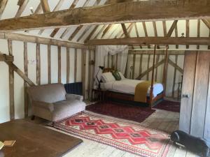 a bedroom with a bed and a chair in a attic at The Granary at Duchess Farm in Sawbridgeworth