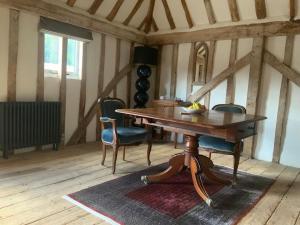 a dining room with a wooden table and chairs at The Granary at Duchess Farm in Sawbridgeworth