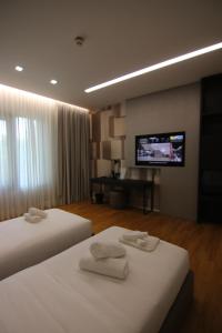 um quarto de hotel com duas camas e uma televisão de ecrã plano em Boutique Hotel Adelar em Tirana
