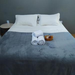 a bed with two towels and a basket on it at Quarto privativo no centro 01 in Itapira