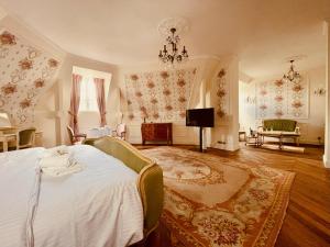 a bedroom with a bed and a chandelier at Château du Prieuré Évecquemont Les Mureaux in Évecquemont