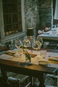 un tavolo con bicchieri da vino e una lampada sopra di Agriturismo Ferdy a Lenna