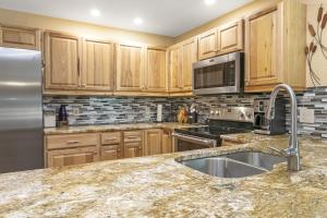 a kitchen with wooden cabinets and a stainless steel refrigerator at 901 Crazy Horse Circle condo in Edwards