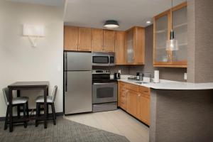 una cocina con armarios de madera y electrodomésticos de acero inoxidable en Residence Inn Birmingham Hoover, en Hoover