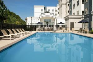 a swimming pool with chairs and a building at Residence Inn Birmingham Hoover in Hoover