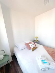 een slaapkamer met een wit bed en een groene tafel bij BOHO * hypercentre * St Georges in Toulouse