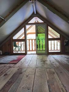 an attic room with a door and a wooden floor at Little Cabins at Km 499 