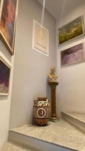 una habitación con un jarrón y pinturas en la pared en B&B Villa Botto, en Cossato