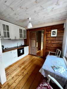 Una cocina con suelos de madera y una mesa en una habitación. en Juveliera apartamenti, en Kuldīga