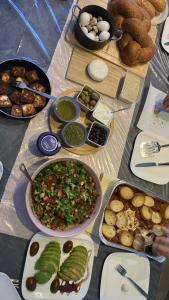 einen Tisch mit vielen verschiedenen Arten von Lebensmitteln in der Unterkunft T&S suite in Dāliyat el Karmil