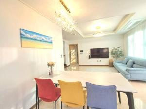 Una sala de estar con una mesa y sillas y un sofá. en Siyoung's House, en Jeju