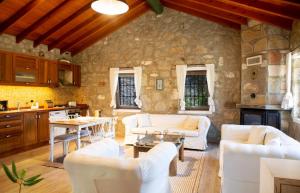 a living room with white furniture and a stone wall at Stone House w Private Pool and Garden in Bodrum in Ortakent