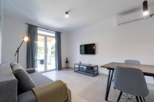 a living room with a couch and a table at The Plaza Ground Floor Apartments in Prizba