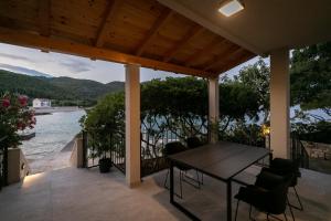 a patio with a table and chairs and a view of the water at The Plaza Ground Floor Apartments in Prizba