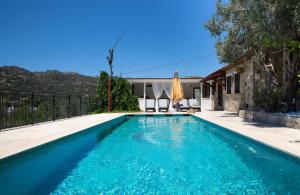 a swimming pool with blue water in front of a house at Stone House w Private Pool and Garden in Bodrum in Ortakent