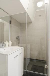 ein weißes Bad mit einer Dusche und einem Waschbecken in der Unterkunft Feel Lisbon B&B in Lissabon