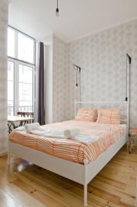 ein Schlafzimmer mit einem großen Bett mit orangefarbenen und weißen Kissen in der Unterkunft Feel Lisbon B&B in Lissabon