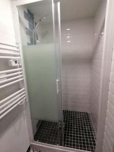 una doccia con porta in vetro in bagno di Gîte Le P'tit Chez Nous a La Rochefoucauld