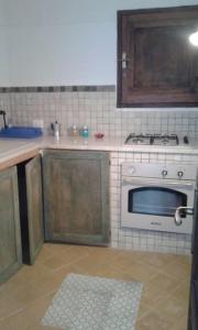a kitchen with a stove and a counter top at Dammusino: mini-appartamento in Pantelleria
