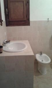 a bathroom with a sink and a toilet at Dammusino: mini-appartamento in Pantelleria