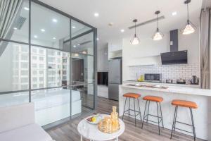 a kitchen with a tub and two bar stools at Vinhomes Dcapital Tran Duy Hung Official in Hanoi