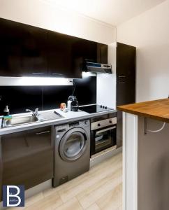 cocina con fregadero y lavadora en Le Bataillon - Confort en Compiègne
