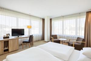um quarto de hotel com duas camas e uma televisão de ecrã plano em Hotel Schillerpark Linz, a member of Radisson Individuals em Linz