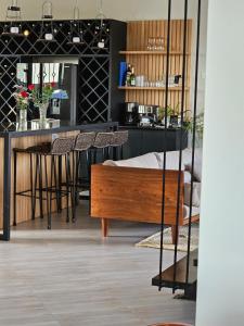 a room with a bed and a bar with chairs at Muguet by Ibiscot development in Kampala
