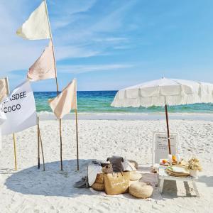 a picnic table on the beach with an umbrella at Sawasdee Coco in Ko Samed