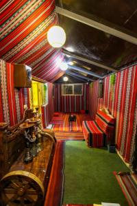 a train car with red chairs and a green carpet at Petra NefNaf Hostel in Wadi Musa