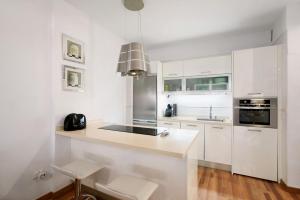 a white kitchen with white cabinets and a sink at Apartamento Playa in Puertito de Güímar