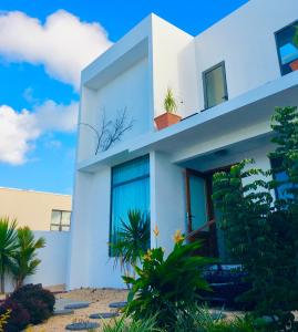 una casa blanca con plantas delante en Balnea Villa Sixty-Nine, en Trou d'Eau Douce