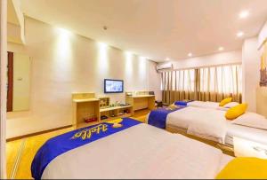 a hotel room with two beds and a desk at 7 Days Inn Foshan Lecong Furniture Branch in Shunde