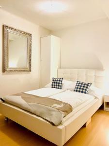 a bedroom with a large white bed with a mirror at Mariazeller Resort Landliebe in Mariazell
