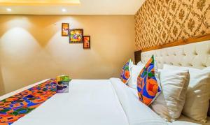 a bedroom with a white bed with pillows at FabHotel SVR in Patna