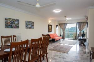 comedor y sala de estar con mesa y sillas en MyRehat Puncak Anthenauem 3 Bedroom, en Kuala Lumpur