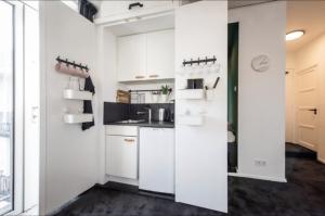 cocina con armarios blancos y encimera en Cozy 2-bedroom apartment en Ámsterdam