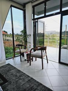 a living room with two chairs and a large window at Muguet by Ibiscot development in Kampala