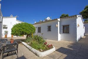 una casa blanca con un banco delante en La Blanqueta- Alcasar, en Moraira