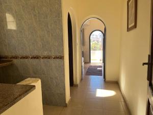 um corredor com um arco e um piso de azulejo em Malaz Motel em Dahab