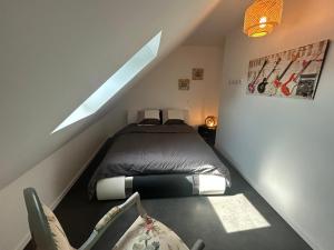 een kleine slaapkamer met een bed op zolder bij Appart stylé très spacieux Sedan 4E in Sedan