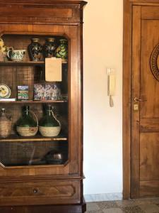 um armário de madeira cheio de tigelas e vasos em Al Numero 5 em Tivoli