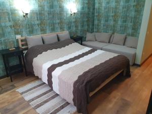 Poiana Golf Chalet في بوستين: غرفة نوم بسرير كبير وأريكة