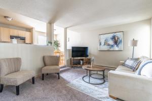 a living room with a couch and a tv at Beautiful and cozy one bedroom apartment -WiFi, BBQ, Patio, Dog park, close to Greenlake and Northgate in Seattle