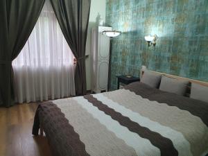 1 dormitorio con cama y ventana en Poiana Golf Chalet, en Buşteni