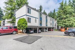 un edificio con coches estacionados en un estacionamiento en Beautiful and cozy one bedroom apartment -WiFi, BBQ, Patio, Dog park, close to Greenlake and Northgate en Seattle