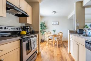 a kitchen with a stove and a table with chairs at Beautiful and cozy one bedroom apartment -WiFi, BBQ, Patio, Dog park, close to Greenlake and Northgate in Seattle